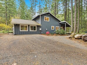 A two-story house with a gravel driveway and a small porch.