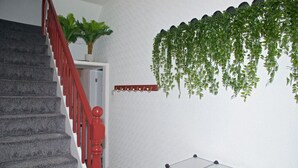 A staircase with red railings, a potted plant, and a hanging plant on the wall. - Comfortable Room in Shared House (Liverpool)