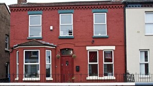 A red two-story house with a bay window, a front door, and a small porch. - Comfortable Room in Shared House (Liverpool)