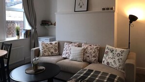 A cozy living room with a sofa, a round coffee table, and a floor lamp.