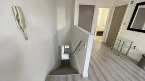 Een modern interieur met een trap, een telefoon en een glazen balustrade.