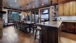Une cuisine spacieuse avec des meubles en bois, un grand îlot central et des luminaires suspendus.