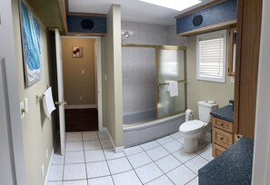 A bathroom with a shower, toilet, and sink.
