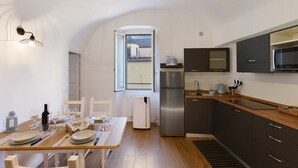 Una cucina moderna con zona pranzo, forno integrato, frigorifero e una finestra con vista.