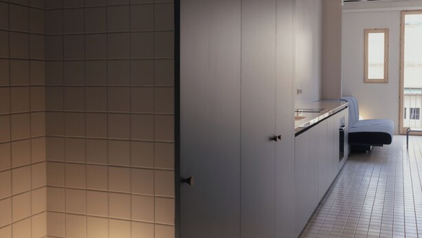 A modern bathroom with a large mirror, a round light fixture, and a bench. - Casa Flor Duplex Boutique Mid-term Barcelona (Barcelona)