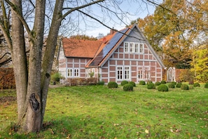 Ett traditionellt hus byggt av tegel med ett sluttande tak och en solpanel.