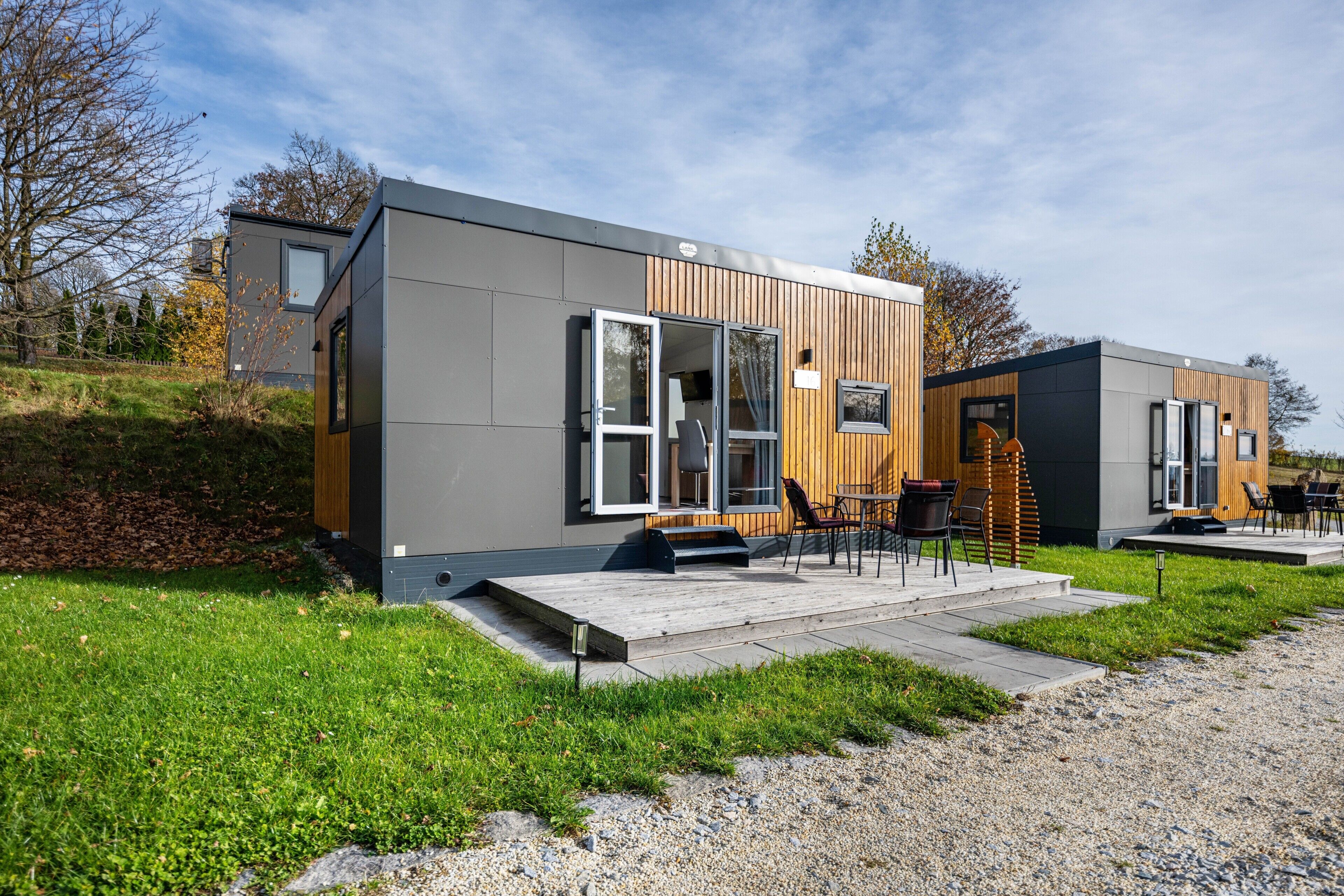 Un bâtiment moderne doté d’un toit plat, de grandes fenêtres et d’une façade en bois.