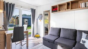 Un salon moderne avec un canapé, un bureau et une fenêtre.