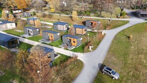 Un quartier résidentiel avec des maisons modernes, une allée sinueuse et une voiture garée.