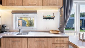 Une cuisine moderne avec des meubles en bois, une fenêtre intégrée et un plan de travail.