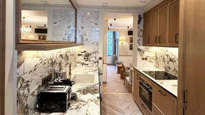 Uma cozinha moderna com bancadas de mármore, armários de madeira e uma torradeira Bosch.