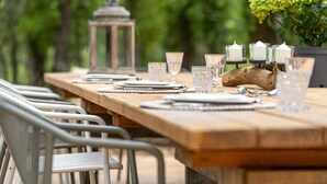 A wooden dining table set with plates, glasses, and candles, surrounded by metal chairs. - House on large 200-hectare estate with swimming pool (Esparron)