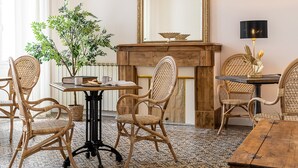 A room with a wooden table, wicker chairs, a potted plant, and a fireplace. - House on large 200-hectare estate with swimming pool (Esparron)