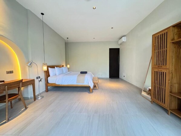 A bedroom with a bed, bedside table, lamp, and wardrobe.