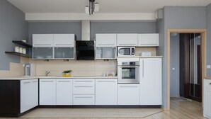 Eine moderne Küche mit weißen Schränken, einer Mikrowelle und einem Backofen.