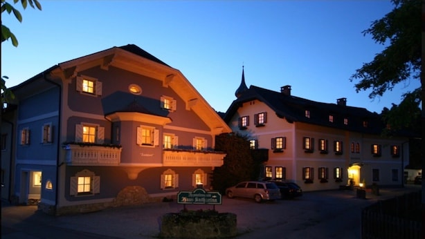 A traditional European-style building with multiple stories, a balcony, and a sign indicating a restaurant. - Apartment '12' with Mountain View, Shared Garden and Wi-Fi (Schladming)