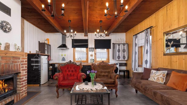 A cozy living room with a fireplace, wooden ceiling, and classic furniture. - Spacious Apartment in Szczyrk | Garden | Parking (Szczyrk)