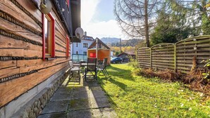 A log cabin with a patio area, a small wooden structure, and a view of a mountain range. - Spacious Apartment in Szczyrk | Garden | Parking (Szczyrk)