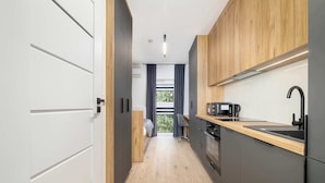 A modern kitchen with a wooden countertop, a black sink, and a built-in oven.