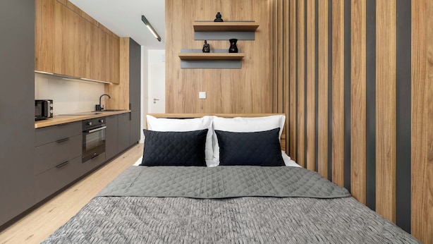 A modern bedroom with a bed, bedside tables, and a built-in wardrobe.