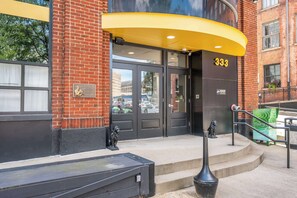 A building entrance with a black door, a yellow awning, and the number 333. - Downtown Cincinnati 2BR | Walk to Reds & Casino (Cincinnati)