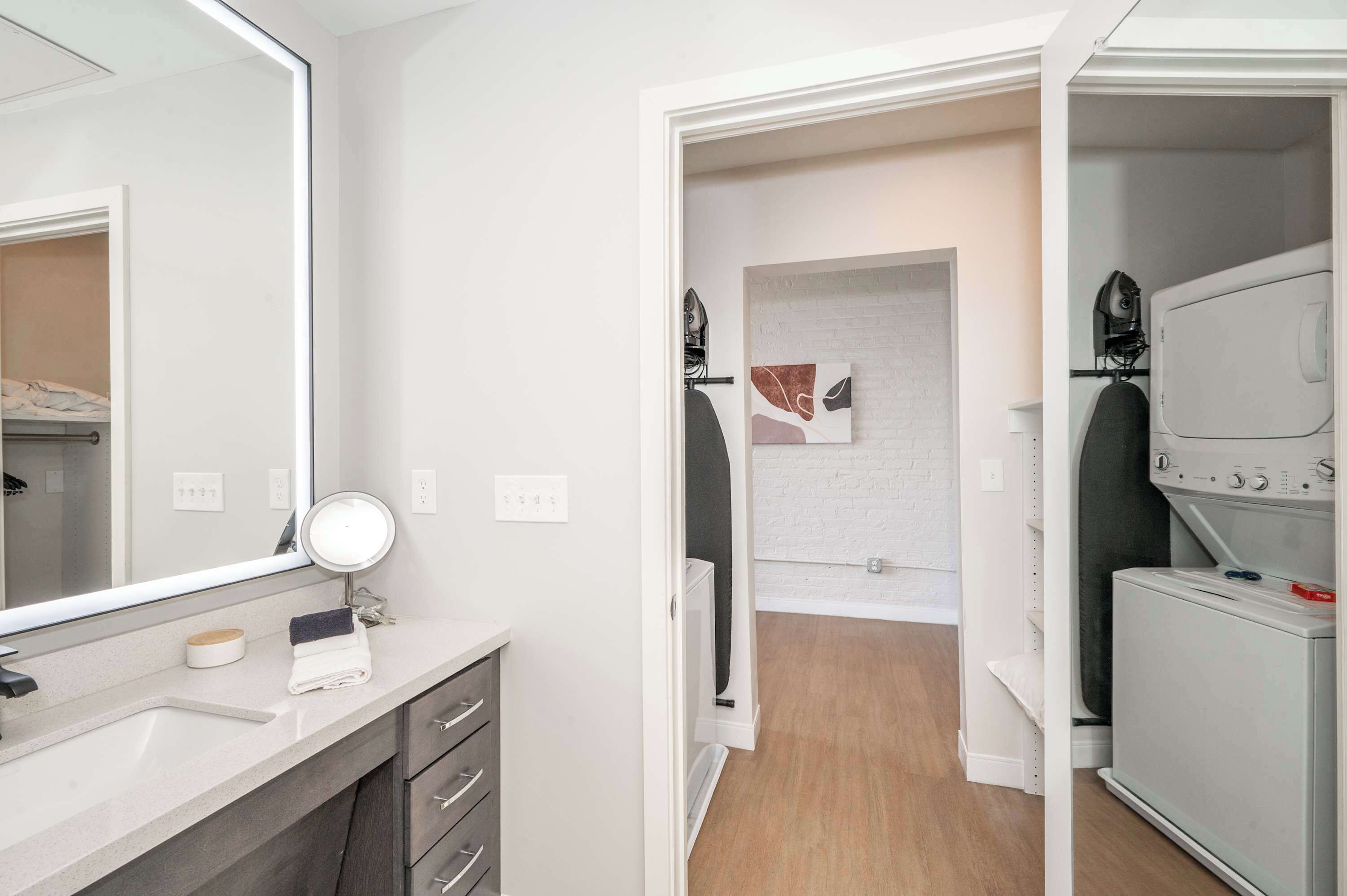 Un baño moderno con un espejo grande, un lavabo y un perchero para toallas.