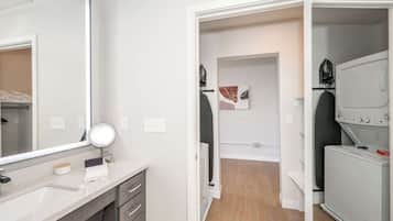 Un baño moderno con un espejo grande, un lavabo y un perchero para toallas.