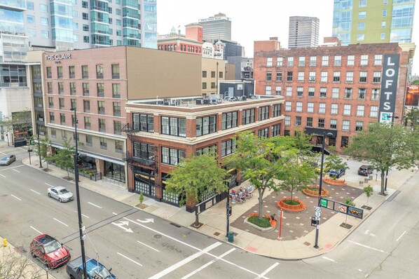 A multi-story hotel with a brick facade, large windows, and a rooftop terrace.
