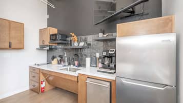 Une cuisine moderne dotée d’appareils électroménagers en acier inoxydable, de meubles en bois et d’un dosseret carrelé.
