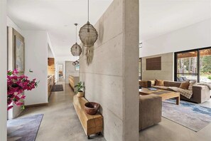 A modern living room with a sofa, coffee table, and hanging lamps.