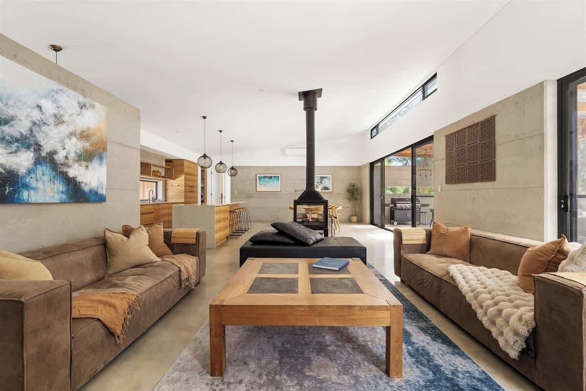 A modern living room with a fireplace, sofas, a coffee table, and artwork on the walls.