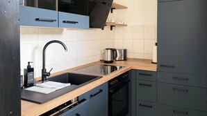 A modern kitchen with a built-in oven, a stainless steel sink, and a coffee maker. - Vacation home Wattglück Tossens Butjadingen - Close to the beach (Butjadingen)