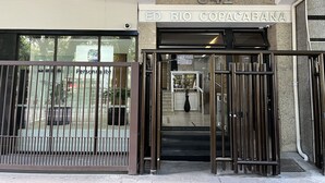 The entrance to a building with a metal gate, a sign reading "ED RIO COPACABANA," and the number "542" above.
