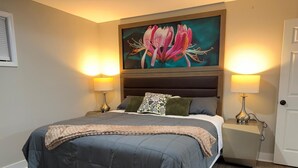 A bedroom with a large bed, two bedside lamps, a painting above the bed, and a door to the right. - 


Inviting Bethesda Stay – Clean, Cozy & Convenient (Bethesda)