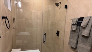 A modern bathroom with a glass-enclosed shower, a glass bathtub, and a towel rack with towels. - 


Inviting Bethesda Stay – Clean, Cozy & Convenient (Bethesda)