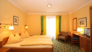A hotel room with a bed, two bedside lamps, a chair, a desk with a computer, and a mirror. - Apartment '22' with Mountain View, Shared Garden and Wi-Fi (Schladming)