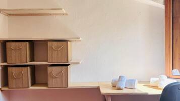 Un bureau d’angle équipé d’un bureau, d’une chaise, d’étagères et de boîtes de rangement.