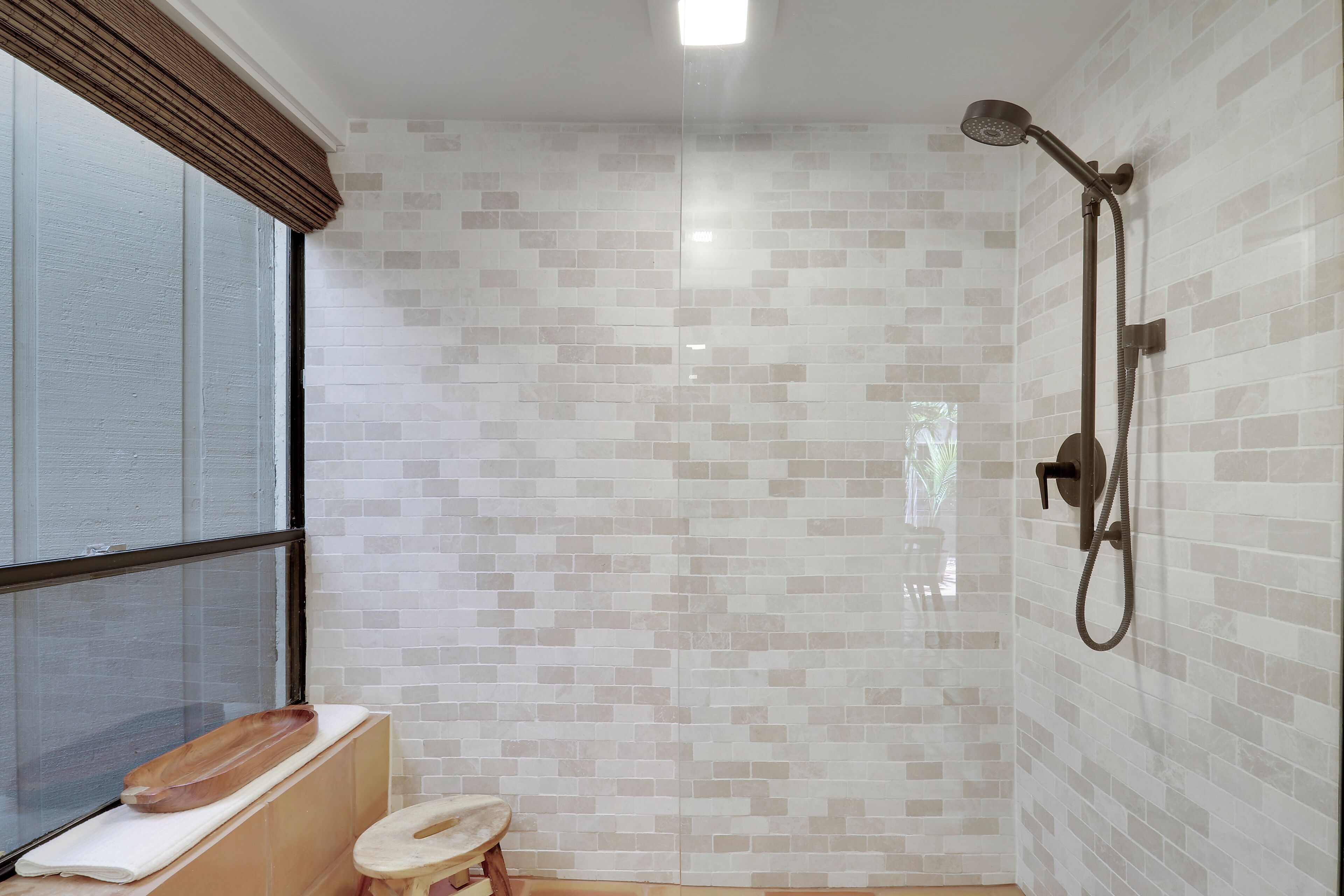 Une salle de bain avec une douche, des toilettes et une fenêtre.
