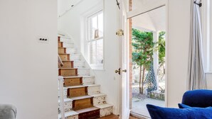 A staircase with white walls and wooden steps leading to a door. - Edinburgh House - sleeps 8 guests  in 4 bedrooms (Burnham Market)