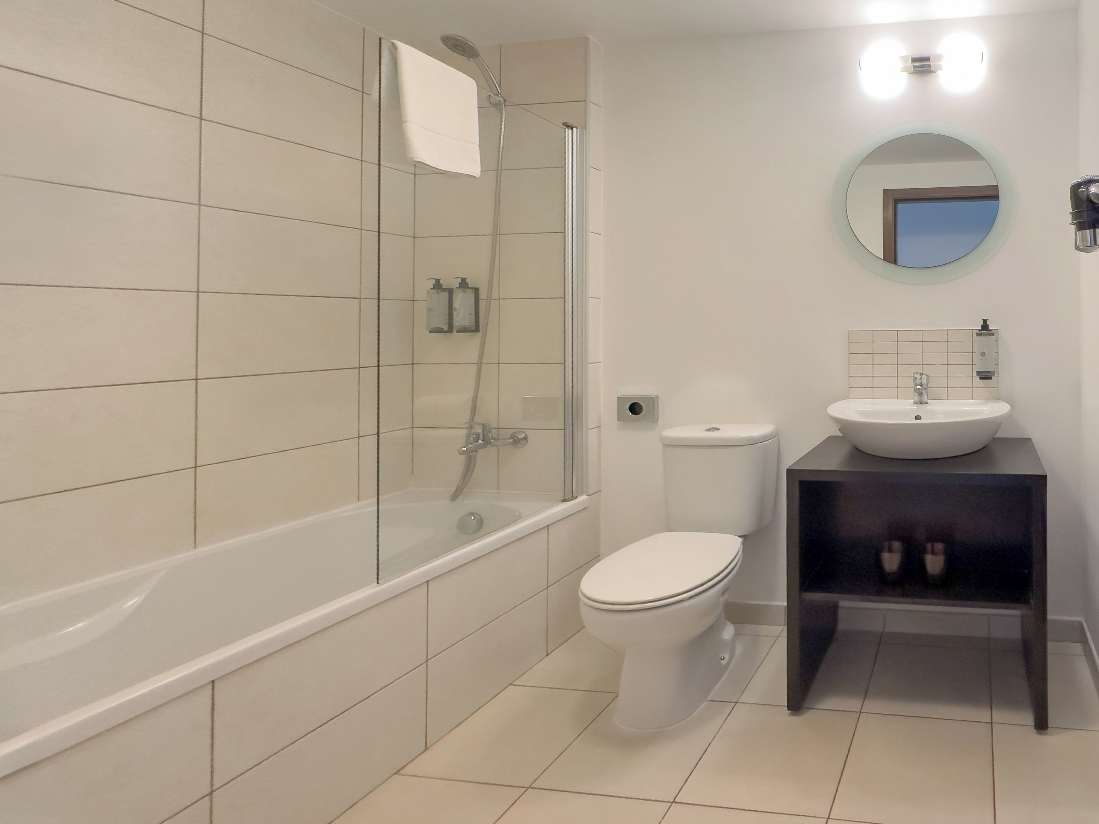 A modern bathroom with a bathtub, toilet, and sink.