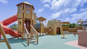 A playground with a slide, climbing structures, and a castle-like playhouse. - Sol Dunas Family Fun (Sal)