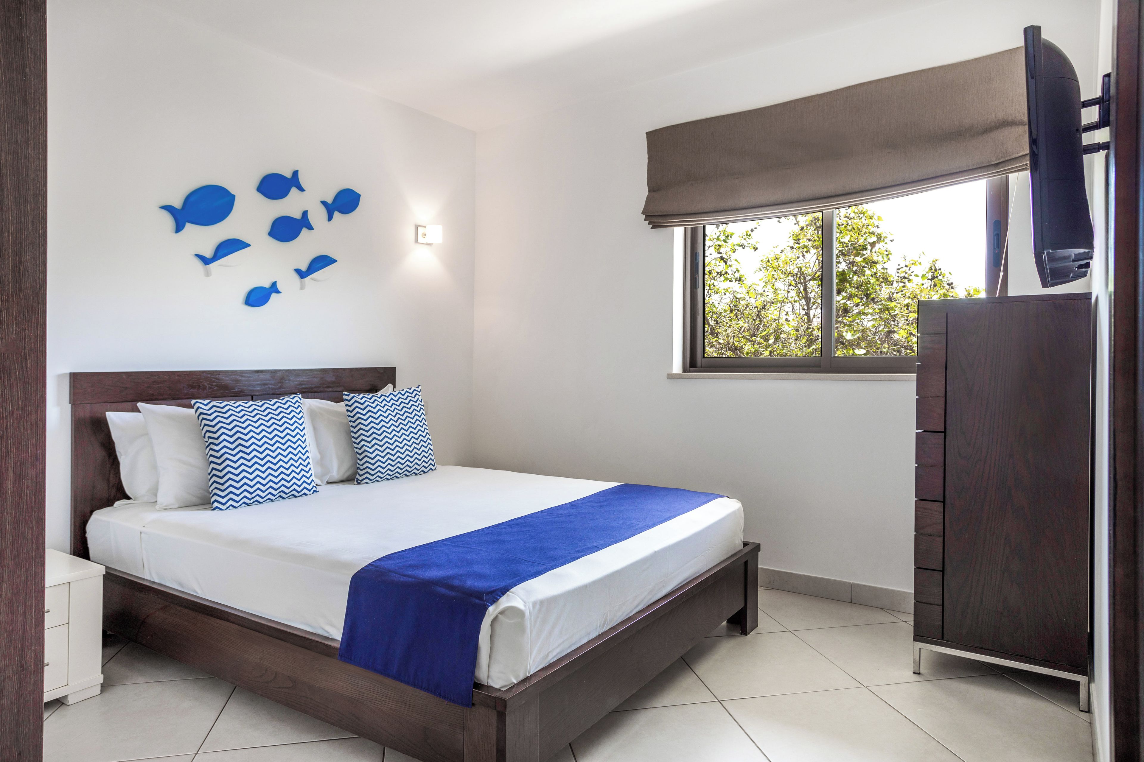 A bedroom with a bed, a wardrobe, a window with a view, and wall decorations.