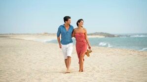 A couple walking on a sandy beach with the ocean in the background. - Sol Dunas Family Fun (Sal)