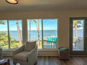 A room with large windows overlooking a deck with chairs and a view of the sea. - Bay front- Boat Dock- Private pool St.George Island (Saint George Island)
