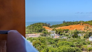 A coastal landscape with a view of the sea, green hills, and scattered buildings. - Praia Brava | Central Itajaí & Balneário Camboriú | 2 Bedrooms, Air Conditioning, Parking Space (Itajaí)