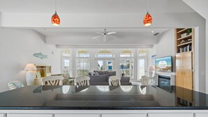 A spacious kitchen with a central island, white cabinetry, and a view to the outside.