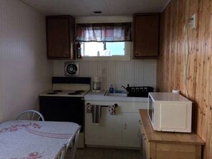 Cafetera o tetera, frigorífico, microondas y placa de cocina