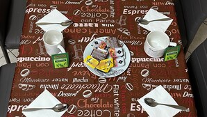 Een eettafel gedekt met verschillende soorten eten, drinken en bestek.