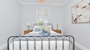 A bedroom with a bed, nightstands, a window with shutters, and a wall-mounted artwork. - Stellaview Estate | Stunning View (Lower Belford)