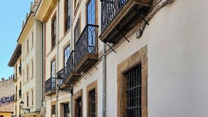 A narrow street with buildings featuring balconies and barred windows. - AH La Crème de la Crème. Oviedo. ENT200112814125 (Oviedo)